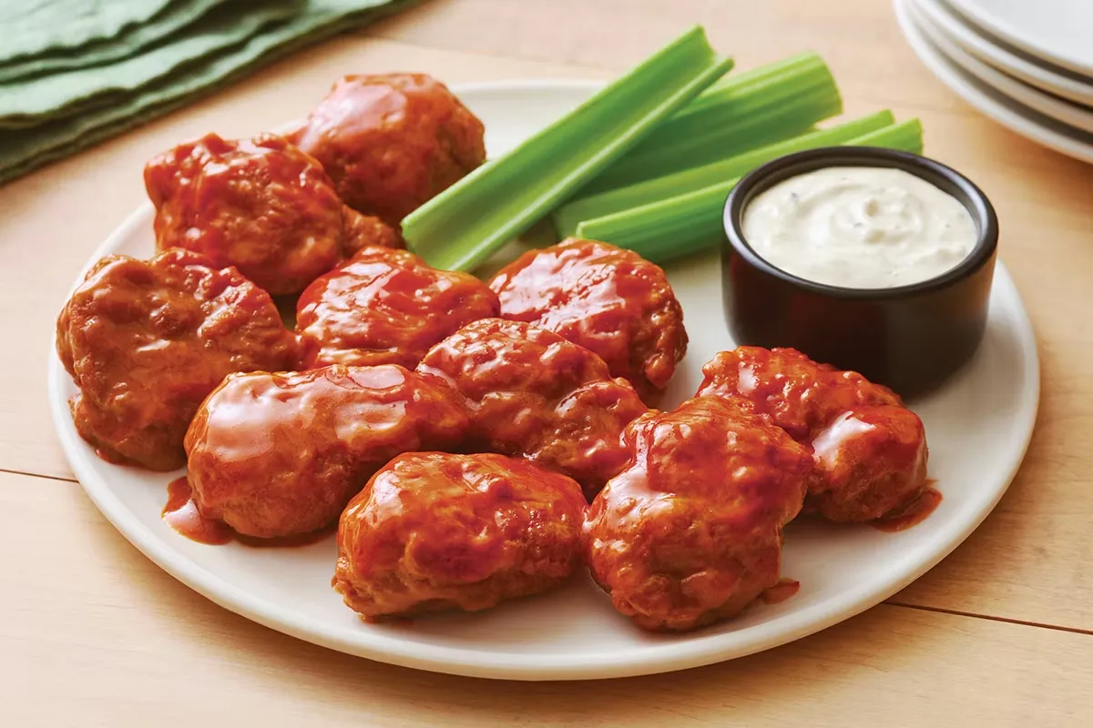 Crispy boneless chicken wings served with dipping sauce on a plate