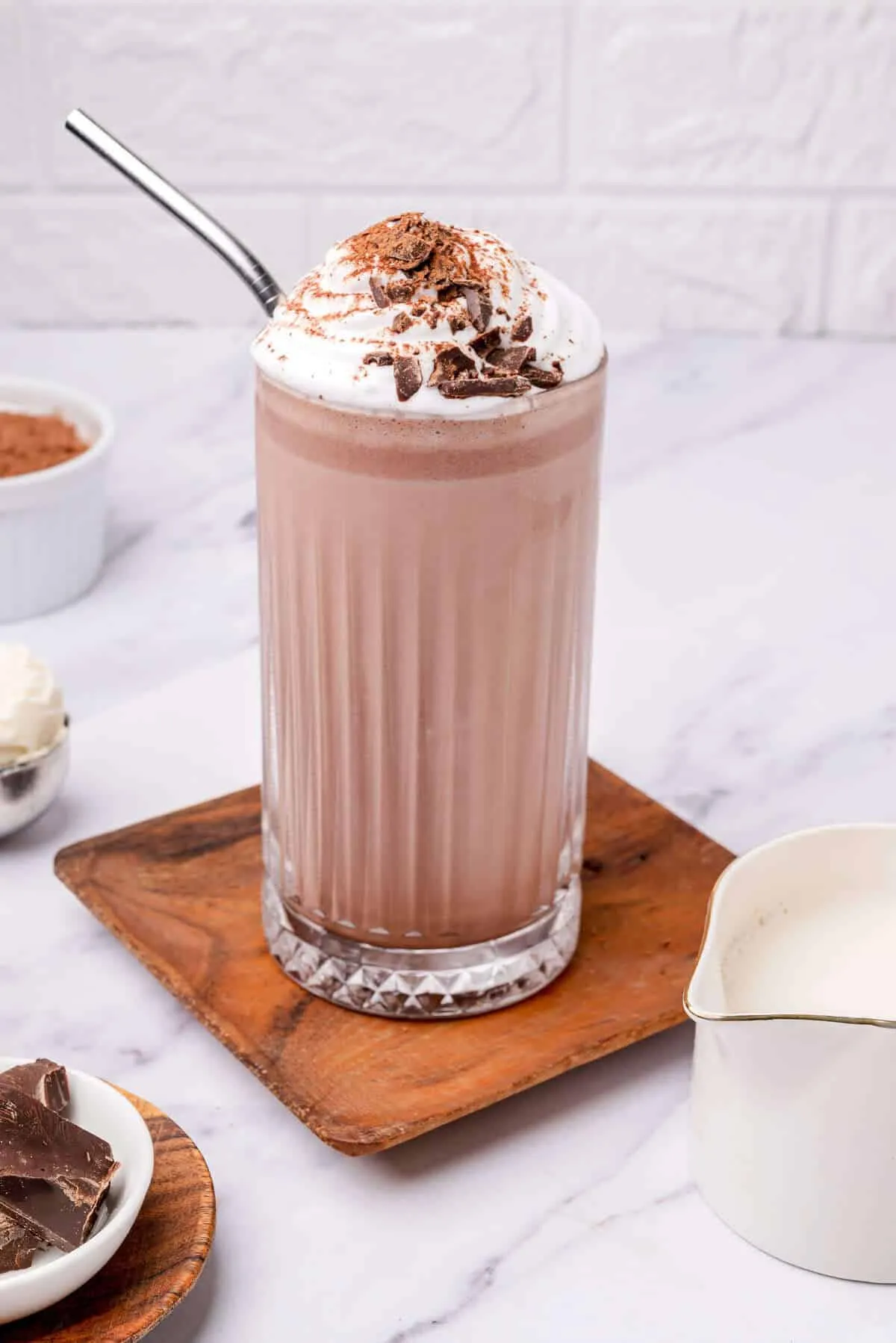 Cold creamy chocolate shake in a glass with ice and cocoa texture