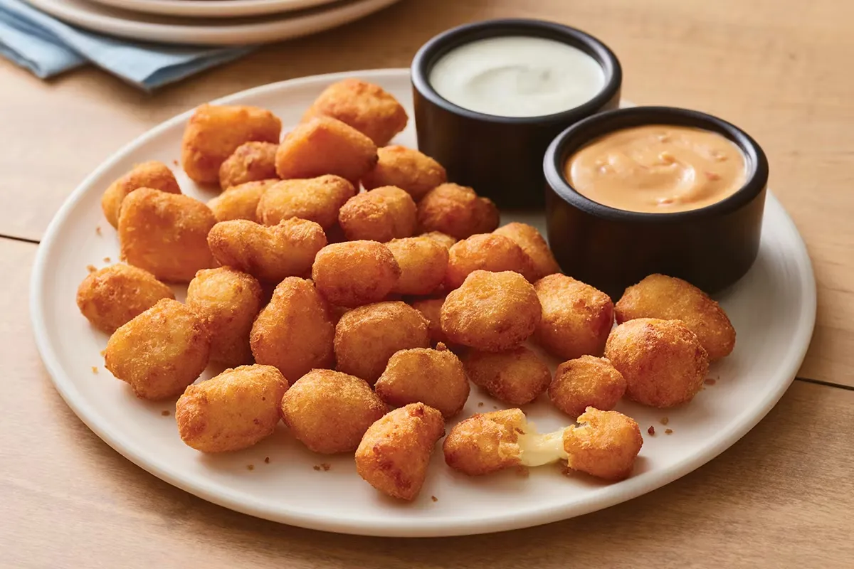 Crunchy fried cheese cubes with melted cheesy center on a plate