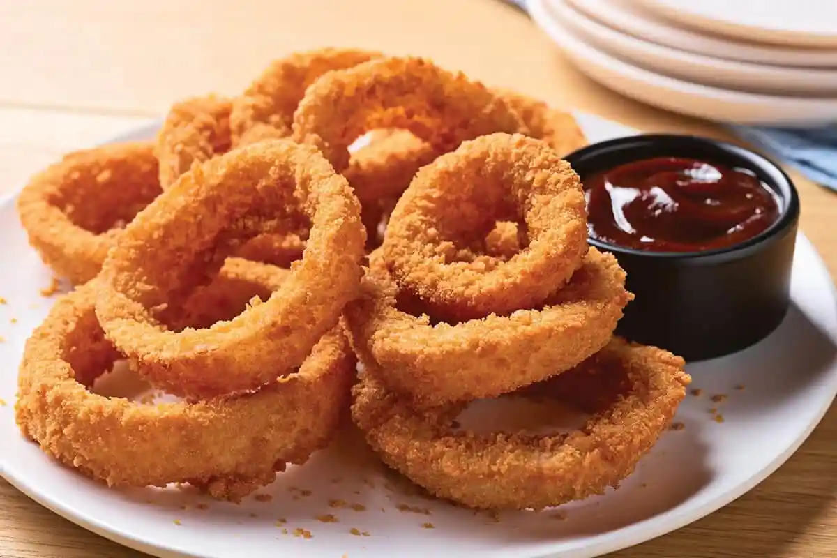 Golden crispy crunchy onion rings served hot and fresh in a bowl