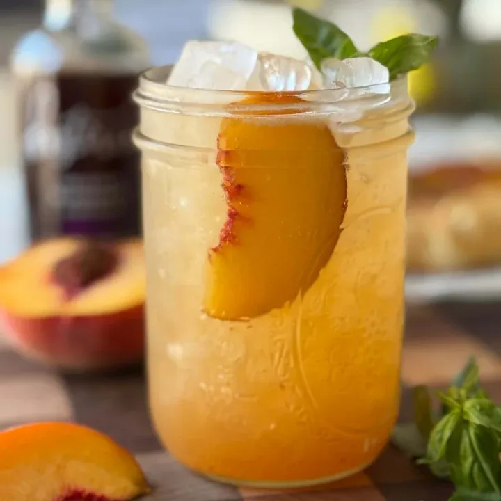 Cold fruity drink made with peach and blueberry chunks over ice