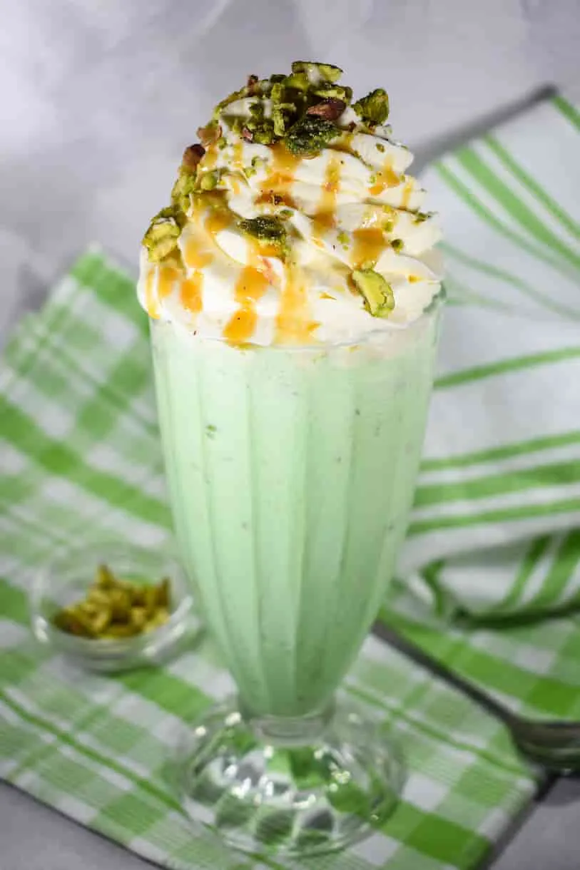 Cold green pistachio shake in a glass with creamy texture