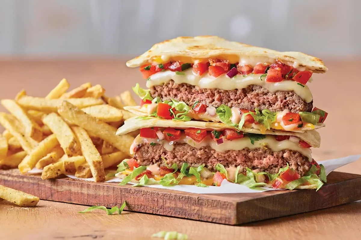 Juicy quesadilla burger with melted cheese and grilled tortilla layers.