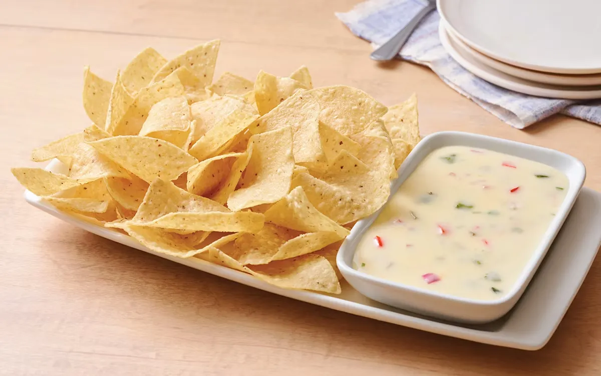 Cheesy white queso sauce with crunchy chips for dipping