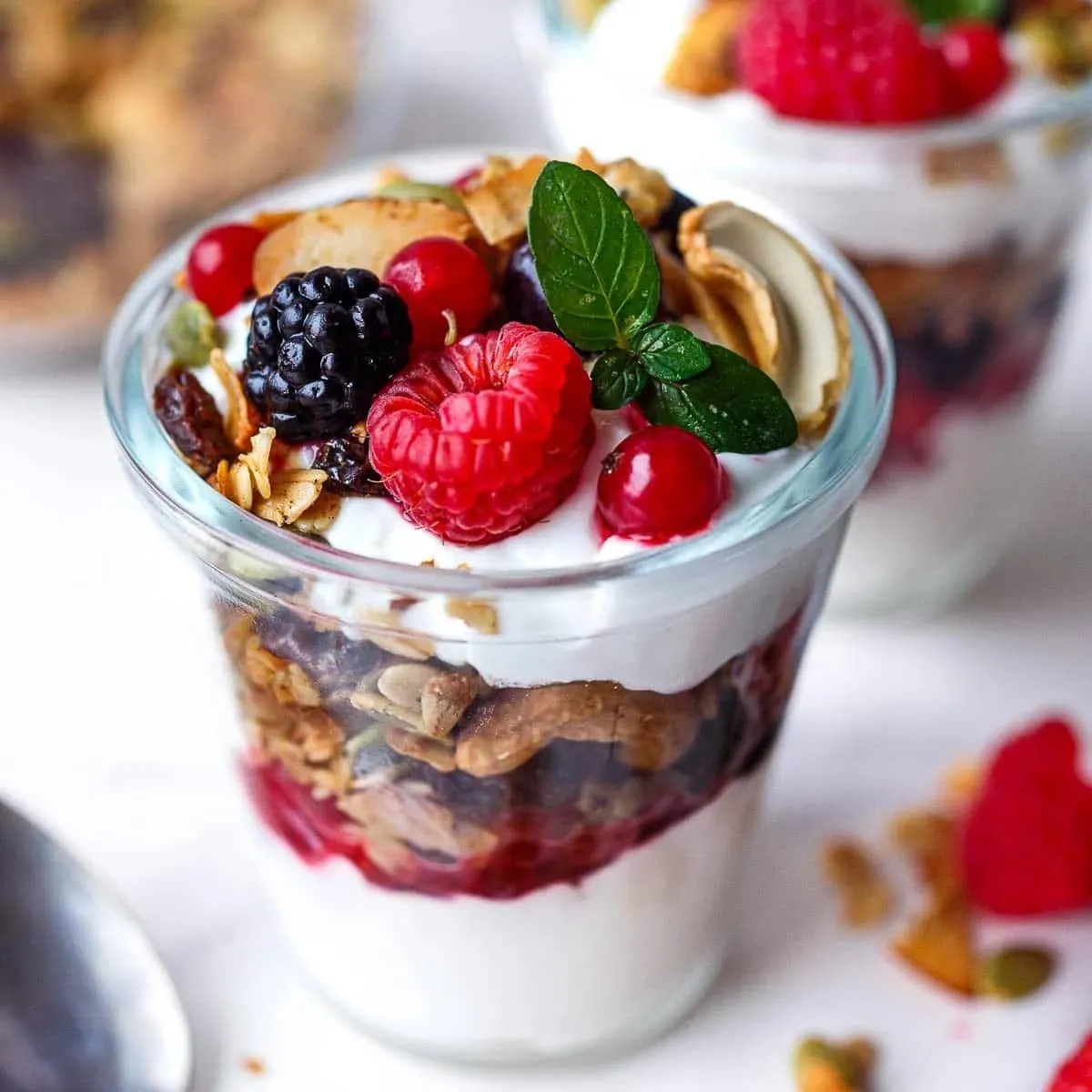 Healthy yogurt parfait served in a glass with berries and crunchy granola.
